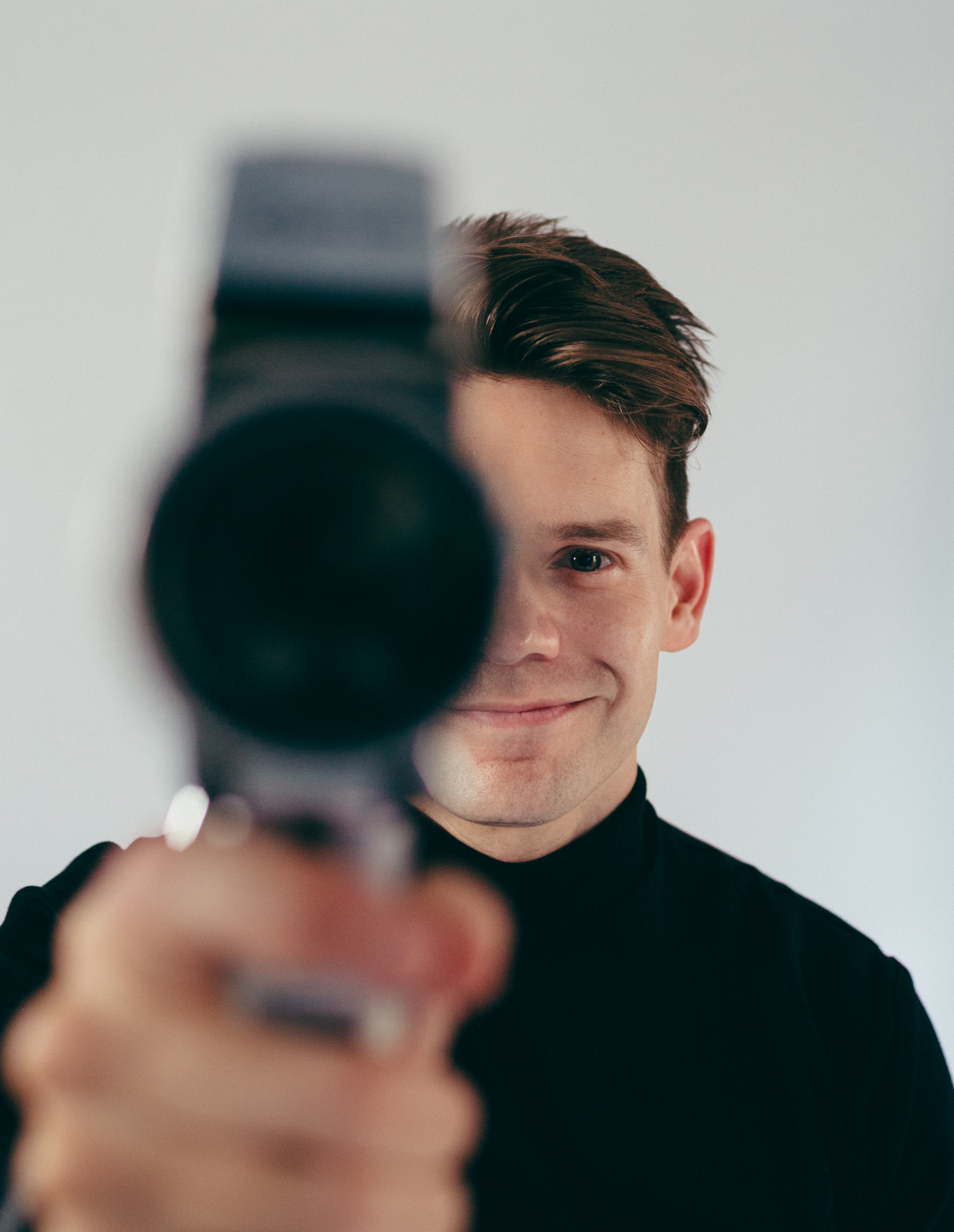 Andrew Keenan-Bolger holding a vintage film camera toward the viewer
